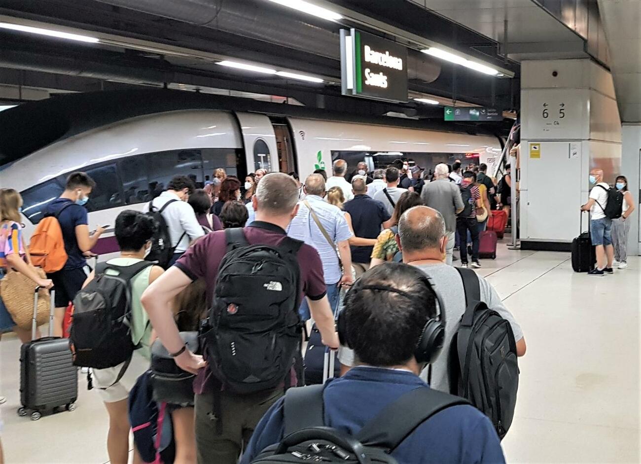 Aglomeración de viajeros con mascarilla en el AVE en Sants