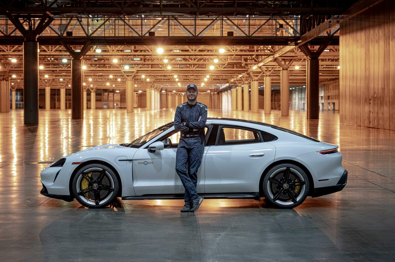 El piloto Leh Keen al lado del Porsche Taycan tras lograr un récord de velocidad dentro de un edificio / PORSCHE
