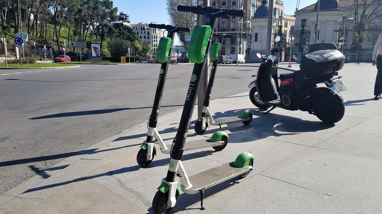 Patinetes eléctricos junto a una moto de 'motosharing' estacionados en Madrid / TF