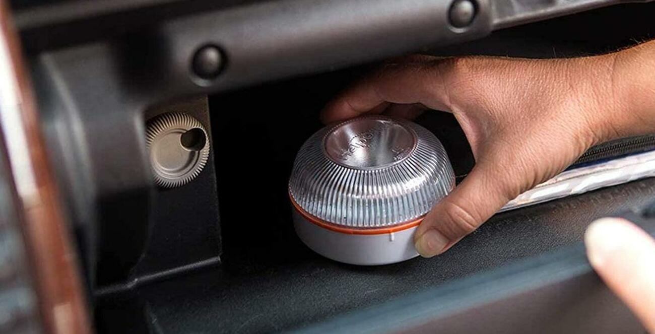 Baliza V16 en la guantera de un vehículo