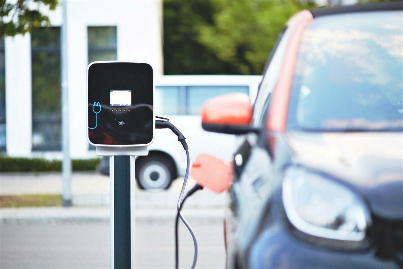 Un coche eléctrico enchufado a un punto de carga Un coche eléctrico enchufado a un punto de carga