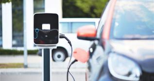 Un coche eléctrico enchufado a un punto de carga Un coche eléctrico enchufado a un punto de carga