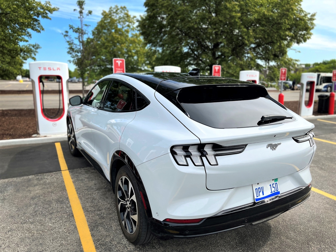 Un Ford Mustang Mach E enchufado a un poste de Tesla / FORD