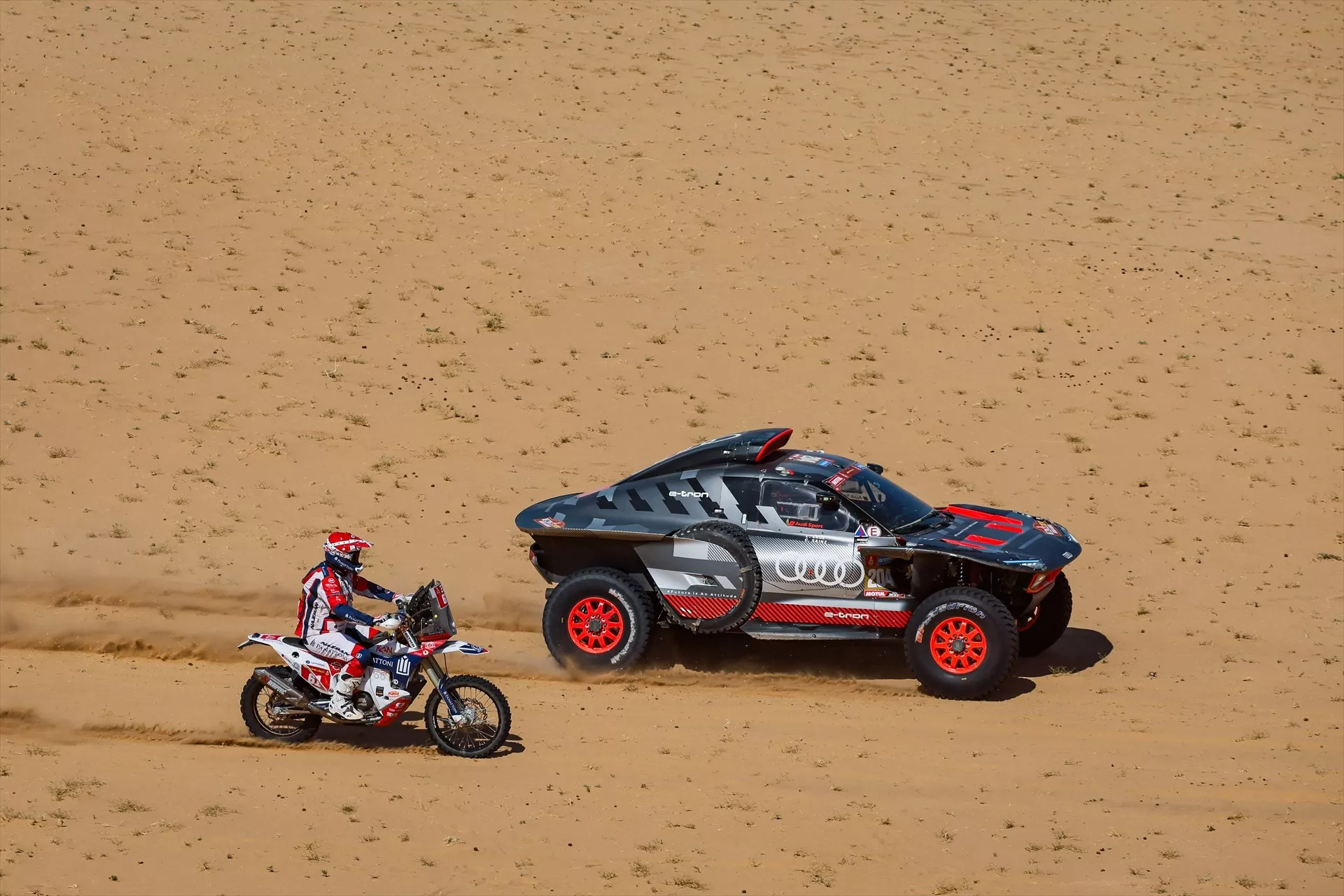 El Audi de Carlos Sainz junto a una moto en el Dakar / DPPI / EUROPA PRESS El Audi de Carlos Sainz junto a una moto en el Dakar / DPPI / EUROPA PRESS