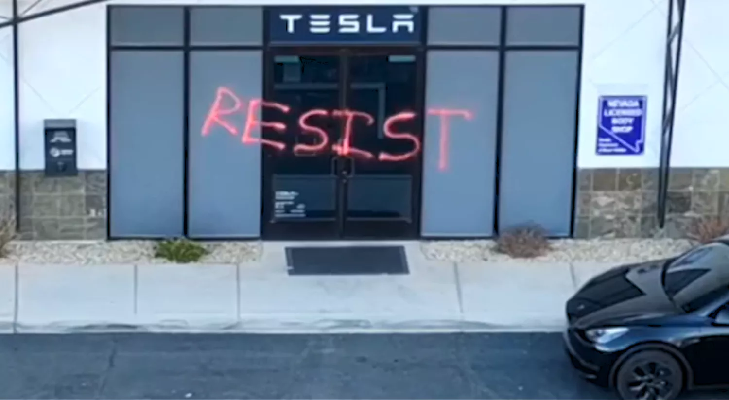 Pintada contra Tesla en un concesionario
