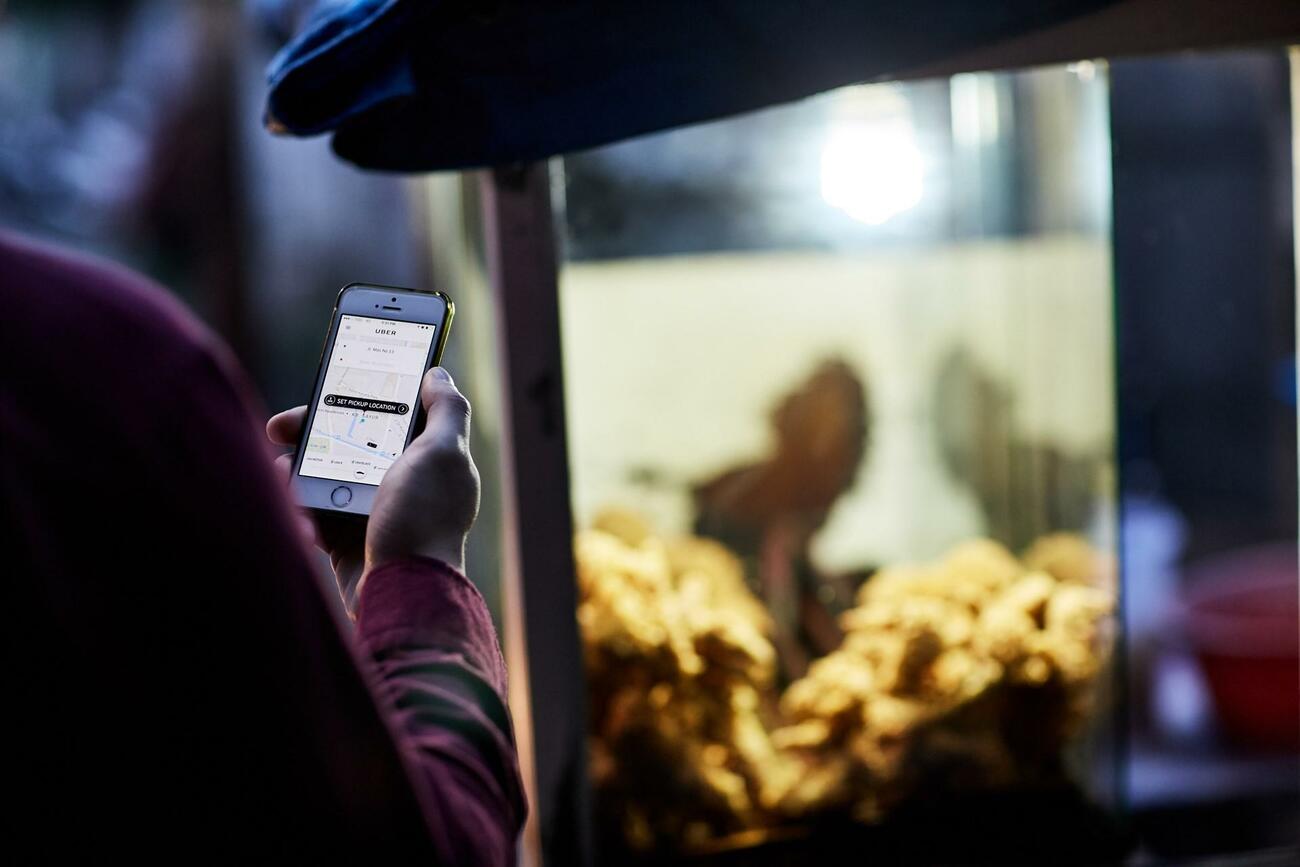 Un cliente entra en la app de Uber para contratar un servicio Un cliente entra en la app de Uber para contratar un servicio