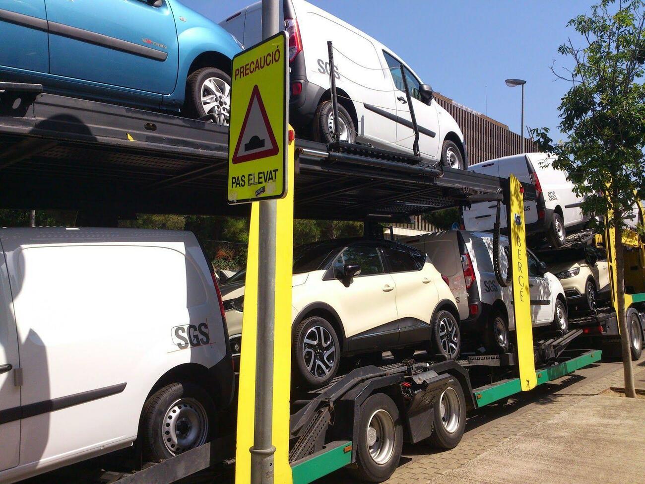 Un camión transporta varios vehículos Un camión transporta varios vehículos