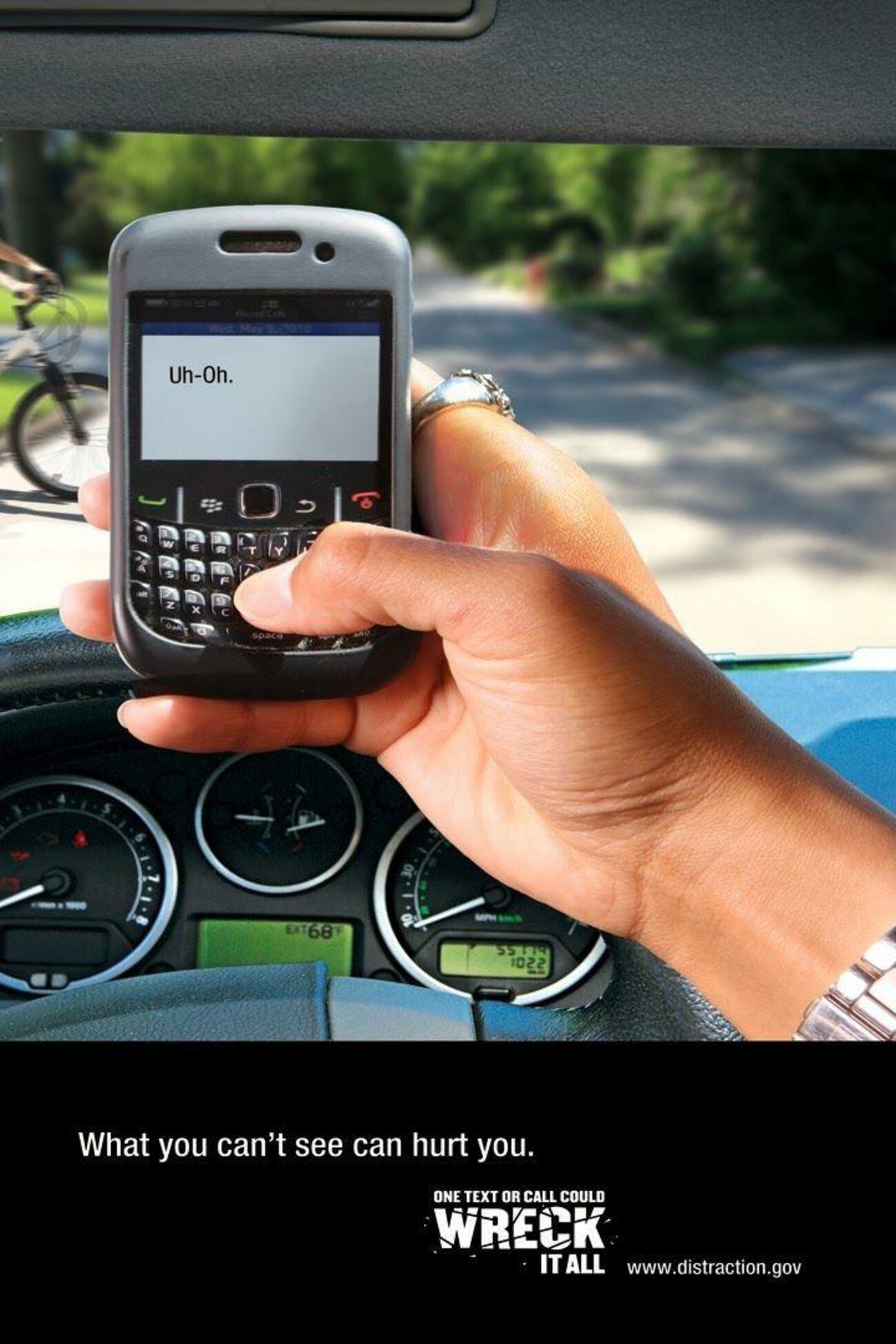 Una mujer teclea su móvil mientras conduce Una mujer teclea su móvil mientras conduce