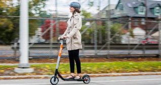 Una chica pasea por una ciudad en patinete, en el que a partir de abril Barcelona obliga al uso del casco  / FORD