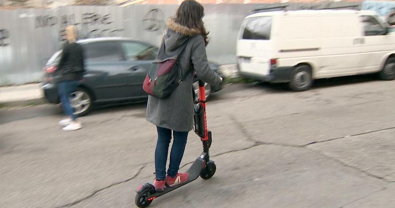 Una mujer conduce un patinete eléctrico / EP