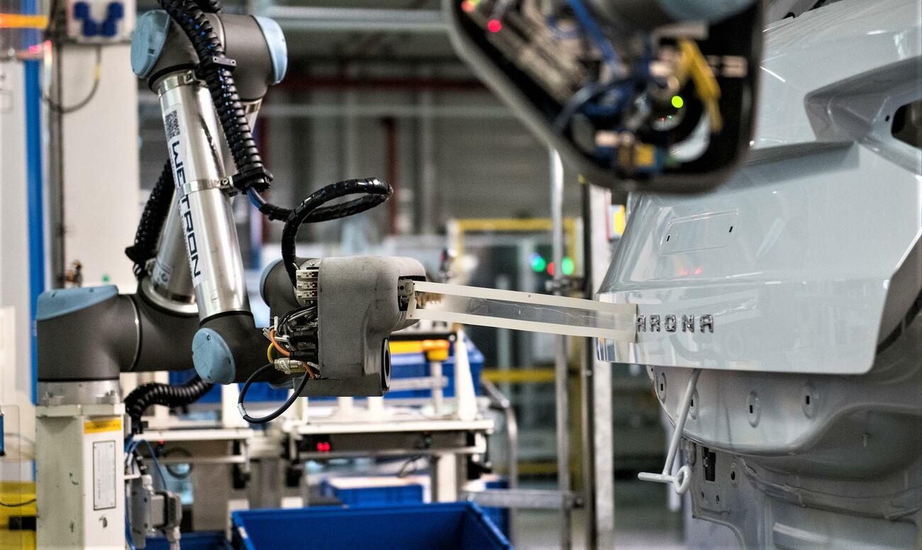 Un robot colaborativo coloca el rótulo con el nombre del modelo Seat Arona / SEAT