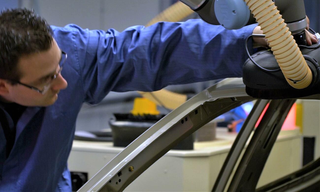 Un empleado con un robot colaborativo de Ford Un empleado con un robot colaborativo de Ford