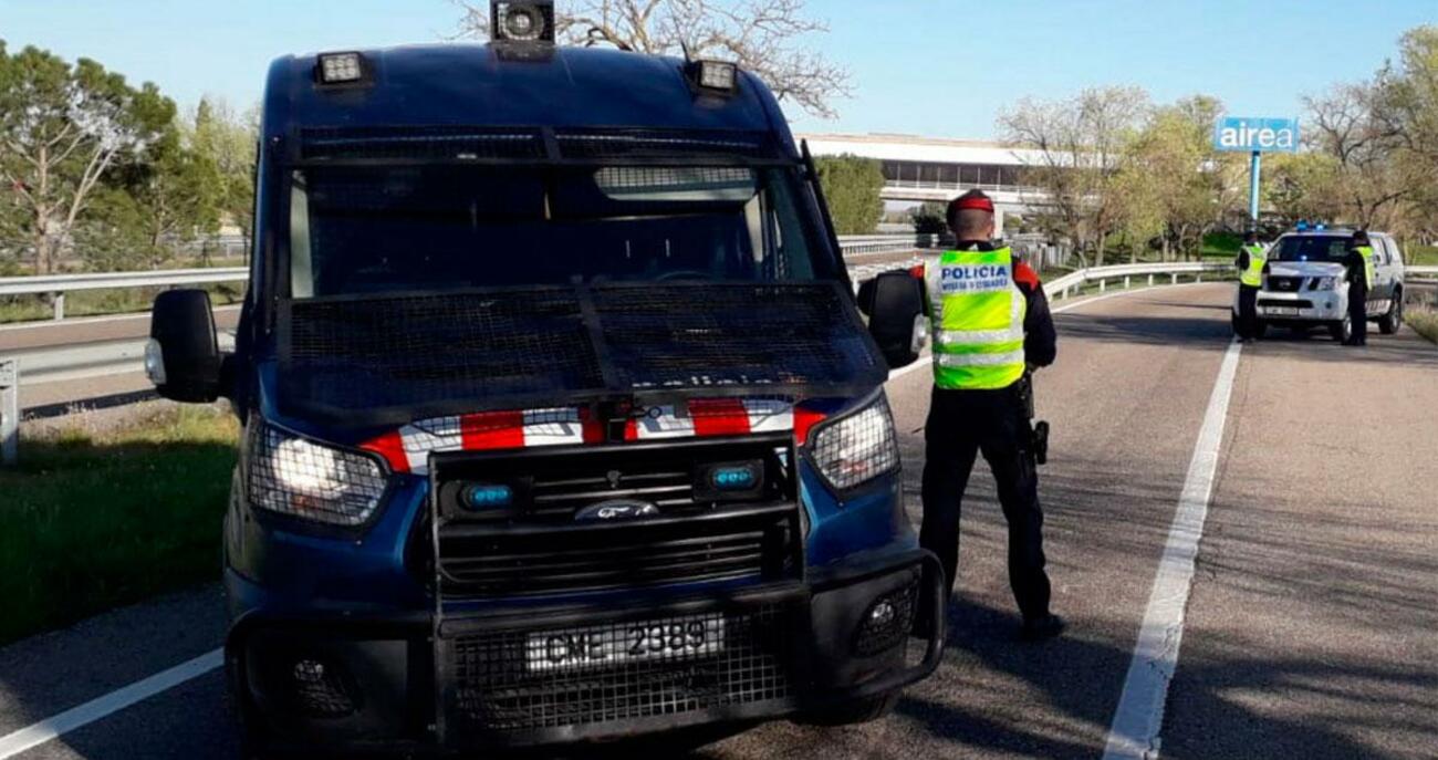 Agentes junto a un furgón de los Mossos ante una población confinada por el coronavirus / MOSSOS