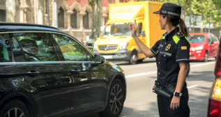 Una agente de la Guardia Urbana dirige el tráfico de vehículos en Barcelona Una agente de la Guardia Urbana dirige el tráfico de vehículos en Barcelona