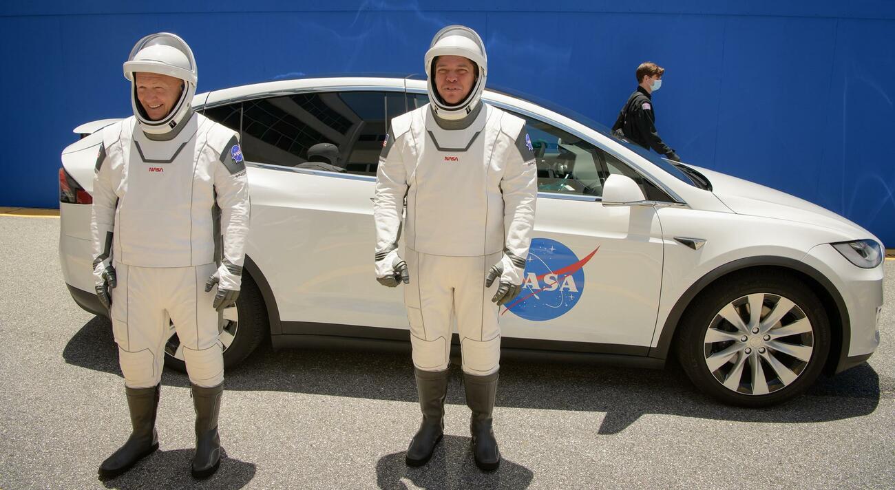 Los astronautas frente al Tesla Model X que los llevó al cohete / NASA